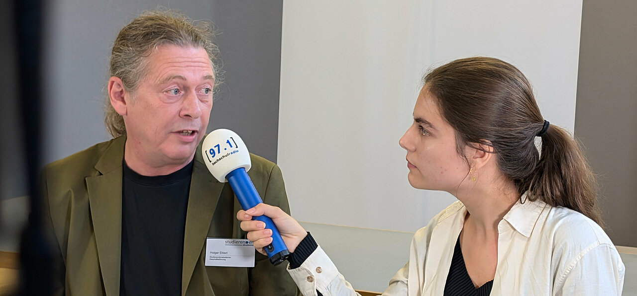 Auf dem Foto ist Holger Ehlert, Geschäftsführer der Studierendenakademie, zusammen mit Johanna Warszawa, Chefredakteurin der Düsseldorfer Campusmedien, zu sehen.