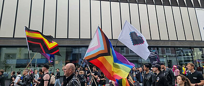 Auf dem Foto ist die CSD Demo in Düsseldorf zu sehen. Es sind Flaggen der trans*, inter* und nonbinären Menschen zu sehen.