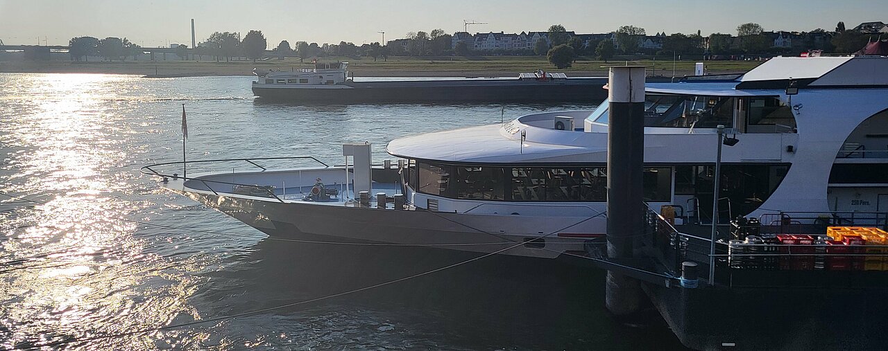 Auf dem Titelbild sieht man ein Schiff auf dem Rhein an der Düsseldorfer Altstadt.