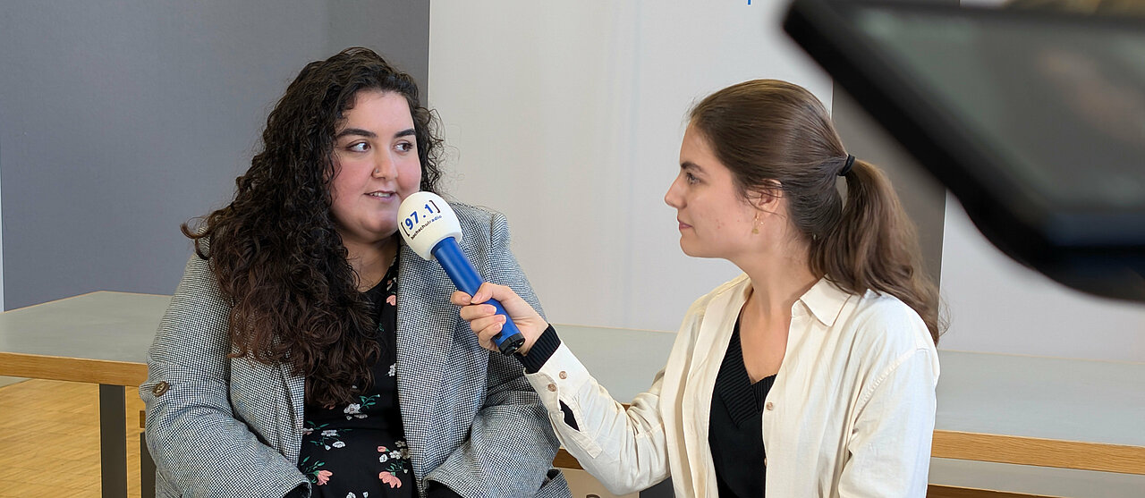 Auf dem Foto ist Elif Benli, AStA-Vorsitzende, Im Gespräch mit Johanna Warszawa, Chefredakteurin der Düsseldorfer Campusmedien, zu sehen.