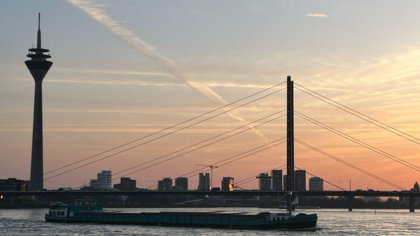 Auf dem Foto sieht man das Düsseldorfer Rheinufer beim Sonnenuntergang. Ein Schiff fährt vorbei (Foto: Anja Händel)