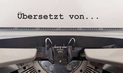 Eine Nahaufnahme einer Schreibmaschine mit dem Schriftzug „Übersetzt Von…“