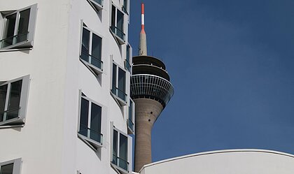 Auf dem Bild sieht man die Gebäude am Medienhafen in Düsseldorf mit Blick auf den Rheinturm bei gutem Wetter(Foto: Michelle Pieczyk)