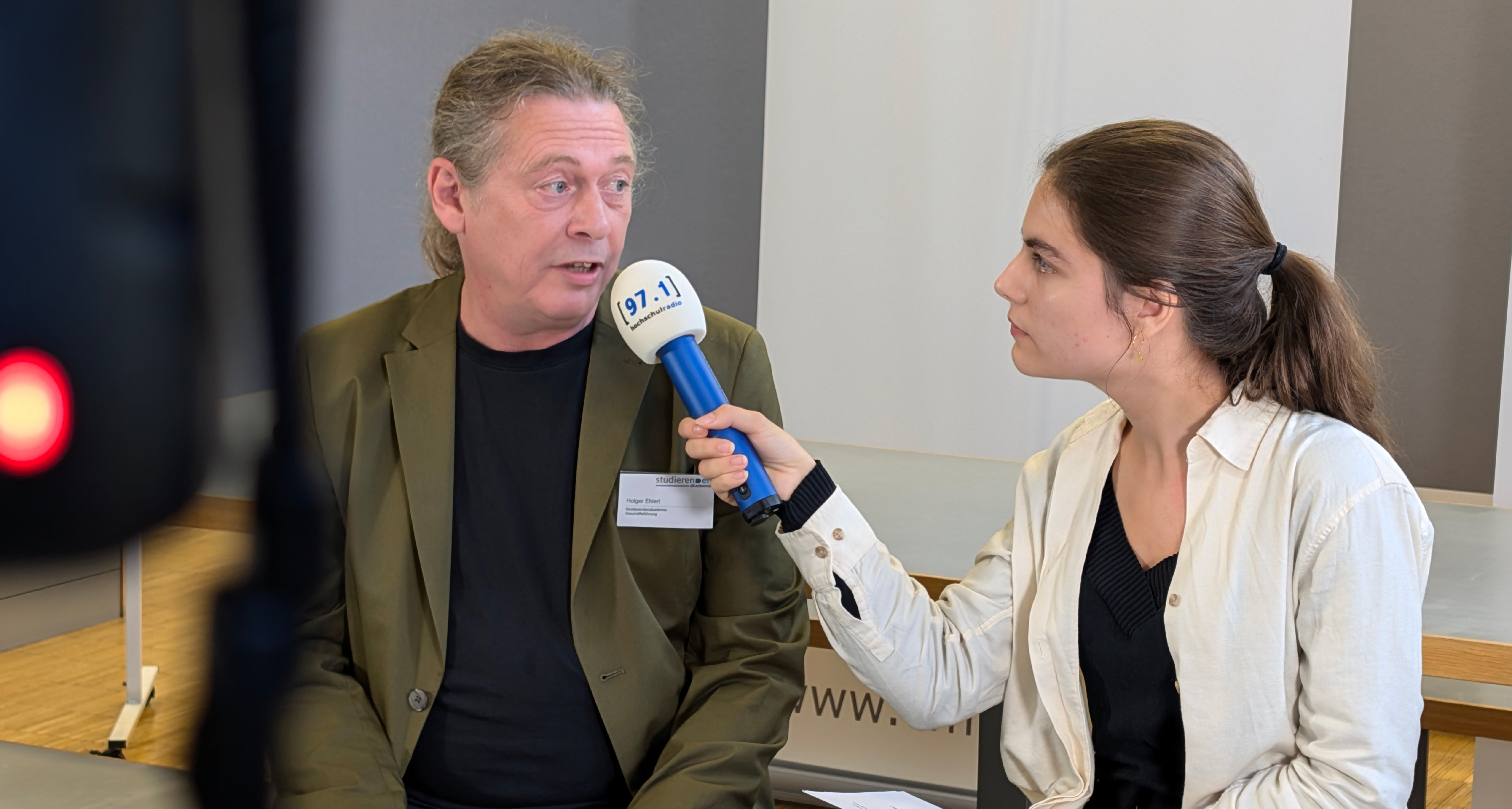 Auf dem Foto ist Holger Ehlert, Geschäftsführer der Studierendenakademie, zusammen mit Johanna Warszawa, Chefredakteurin der Düsseldorfer Campusmedien, zu sehen.